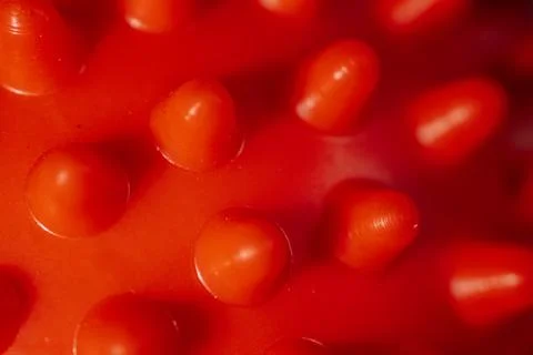 A close-up of a red rubber surface with evenly spaced. Stock Photos