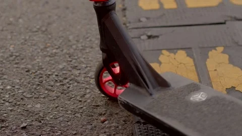 Close-up of red scooter wheel rolling over yellow tactile paving 库存影片 347204783