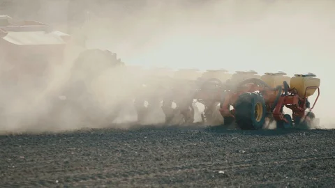 Close-up. The red seeder sows corn on the ground. Stock Footage 128365614