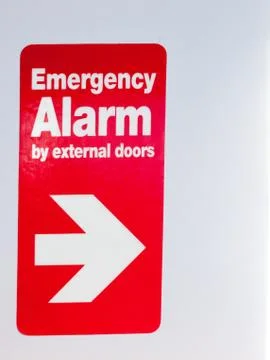 Close up of red sign with direction emergency alarm by external sign inside t Stock Photos