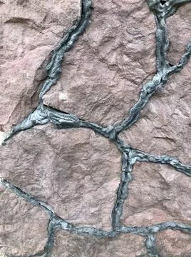 Close-up of a red stone wall . Wall of sharp stones Stock Photos