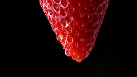 Close-up of the red strawberry with drops of water flowing down the surface Stock Footage 138014000