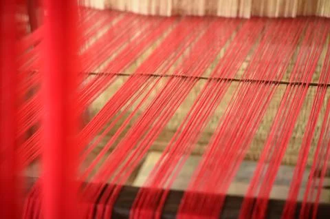 Close up red thread from weaving machine traditional craft Stock Photos
