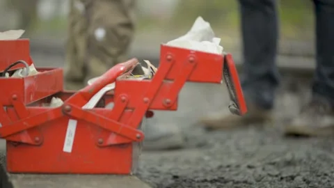 Close-up of a red toolbox with focus shifting towards a person's legs on a Stock Footage 281319058