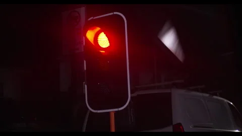 Close Up Red Traffic Light at Night, Blinking Orange Glow Illuminating street Stock Footage 332180829