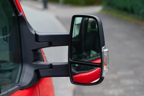 Close-up of a red vehicle's side view mirror, with a clear view. Stock Photos