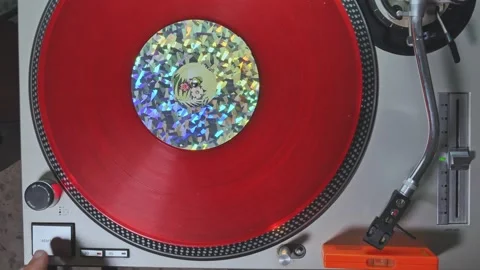 Close up of a red vinyl record on the turntable carpet being started for play Vídeo Stock 208054107