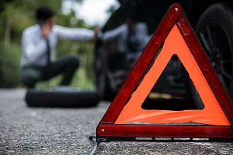 Close of red warning triangle and man blur background. Stock Photos