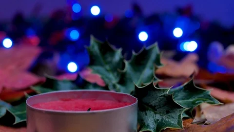 Close-up on a red wax candle and christmas holly. Stock Footage 99442003