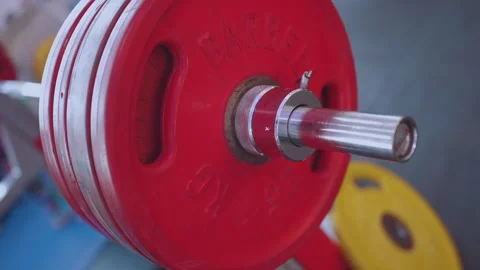Close-up of red weights on a barbell, shooting in slow motion Stock Footage 245607492
