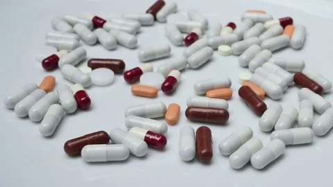 Close up, with red, white, brown, orange pills rotating Stock Footage 81007148