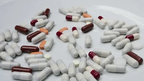 Close up, with red, white, brown, orange pills rotating Stock Footage 81049439