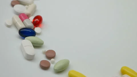 Close up, red, white, colored pills rotating, from the left side Stock Footage 85742941