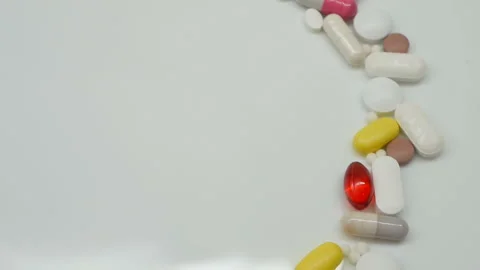 Close up, with red, white, colored pills rotating, from the right side Stock Footage 85743139
