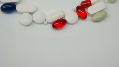 Close up, with red, white, colored pills rotating, from the the top side Stock Footage 85743170