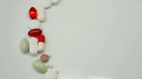Close up, with red, white, colored pills rotating, from the left side, copy spac Stock Footage 86213706