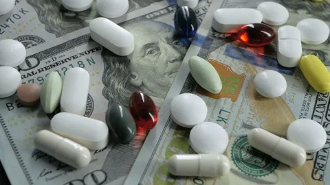 Close up, with red, white, colored pills rotating on dollars banknotes on black Stock Footage 91270455