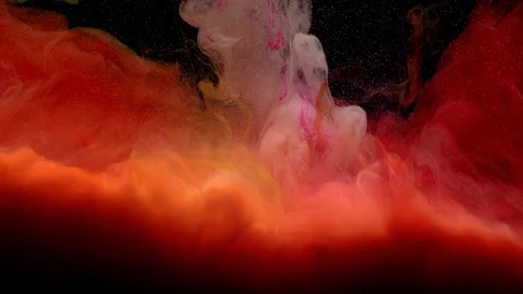 Close-up of red, yellow, white, orange and pink paint settles to the bottom Stock Footage 114320930