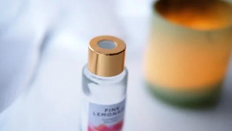 Close up of a reed diffuser bottle with wooden sticks and a scented candle Stock Footage 113753525