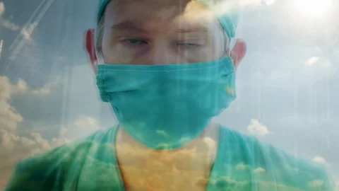 Close up reflection of a doctor looking out of a window Stock Footage 87014288