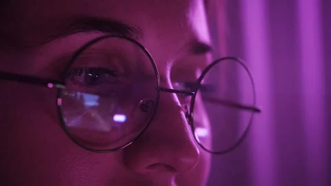 Close-up of reflection in glasses. Gamer plays video games on a computer at Stock Footage 256089291