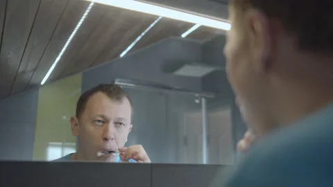 Close-up reflection of a young man in the mirror, brushing teeth, daily dental Stock Footage 155068502