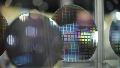 Close-up of reflective silicon wafers displaying colorful microchip die grids Video stock 333839449