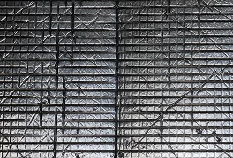 Close-up of a reflective silver-coloured surface with diagonal lines Foto stock