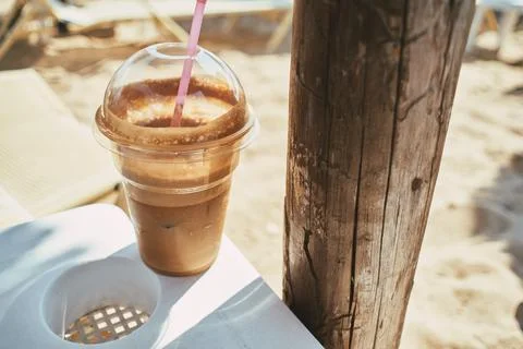 Close-up of a refreshing cold iced coffee frappe in a plastic cup with a stra Stock Photos
