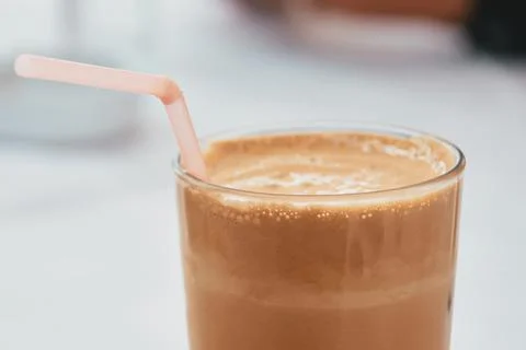 Close-up of a refreshing cold iced coffee frappe in a glass with a straw Stock Photos