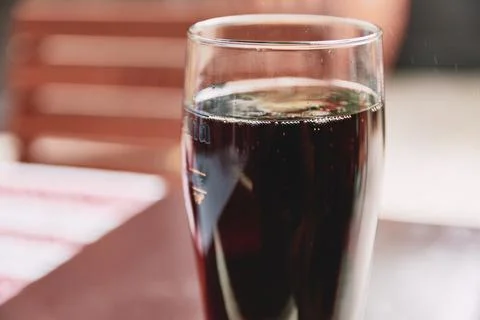 Close-up of a refreshing dark beverage in a tall glass on a table Stock Photos