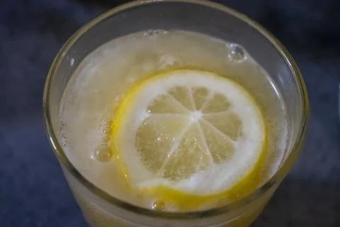 Close-up of a refreshing drink with lemon slice, perfect for summer vibes Stock Photos