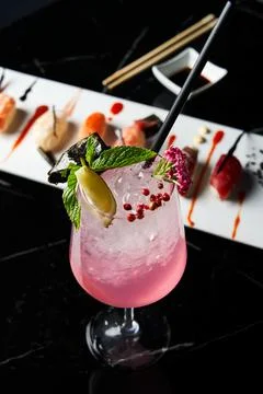 Close-up of a refreshing drink with white plate of sushi pieces. Stock Photos