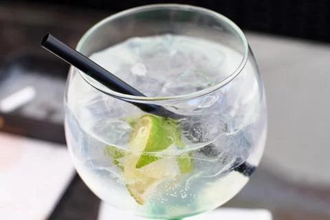 Close-up of a refreshing gin and tonic cocktail with ice and lime slices Stock Photos