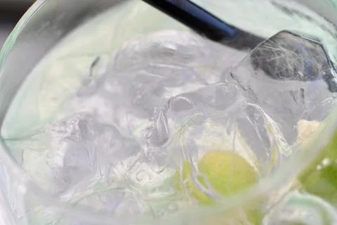 Close-up of a refreshing gin and tonic cocktail with ice cubes and lime slice Stock Photos