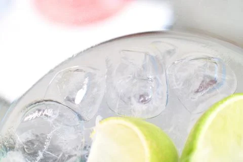 Close-up of a refreshing gin and tonic cocktail with ice cubes and lime wedge Stock Photos