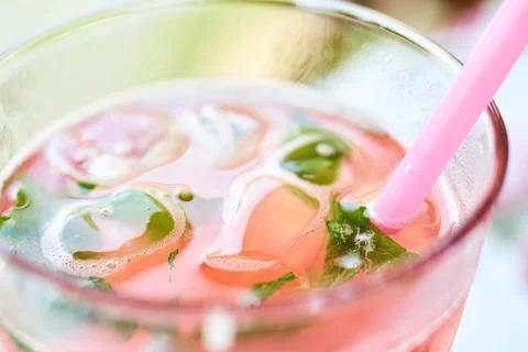 Close-up of a refreshing glass of raspberry lemonade with ice and a pink stra Stock Photos