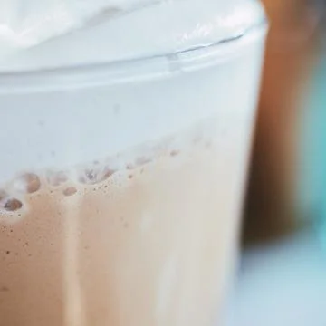 Close-up of a refreshing iced coffee beverage with thick creamy milk foam lay Stock Photos