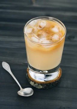Close-up of a refreshing iced coffee with milk in glass on a wooden black table. Stock-Fotos