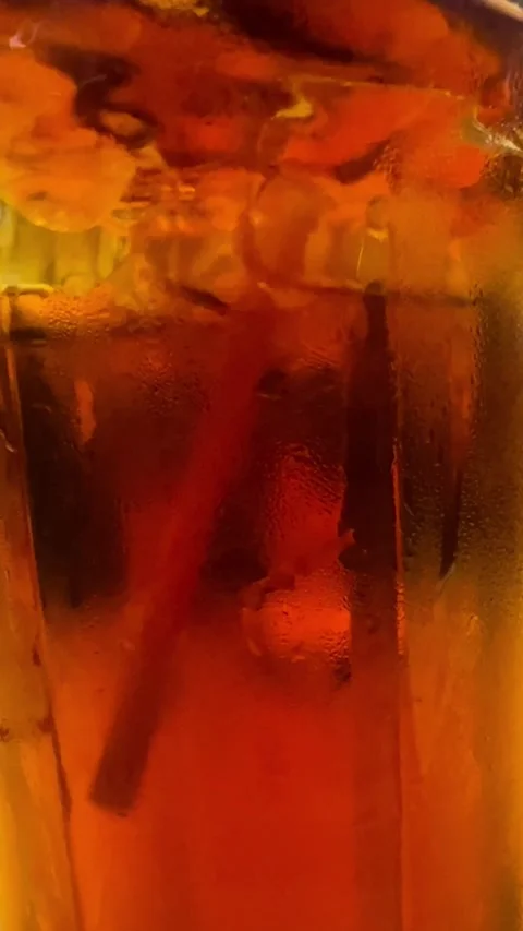 Close up of refreshing iced tea with condensation and ice cubes in a glass. 스톡 동영상 335914247