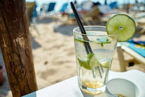 Close-up of a refreshing mojito cocktail with lime and mint on a beach Stock Photos