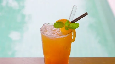 Close up of refreshing orange drink with mint leaf and ice Stock Footage 238693164