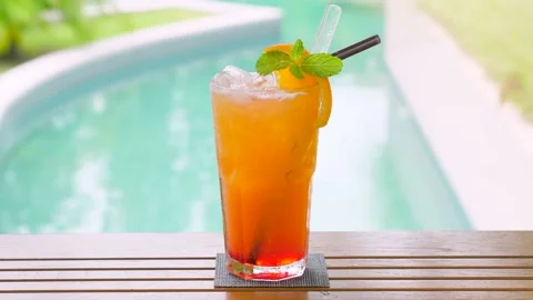 Close up of a refreshing orange drink with straw and mint leaf Video stock 237017384