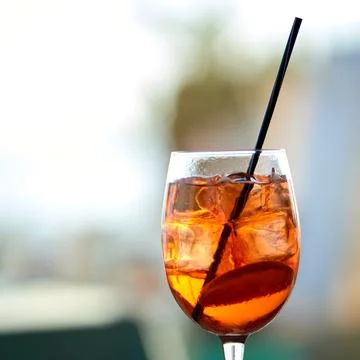 Close-up of a refreshing orange spritz cocktail with ice cubes and a black .. Stock Photos