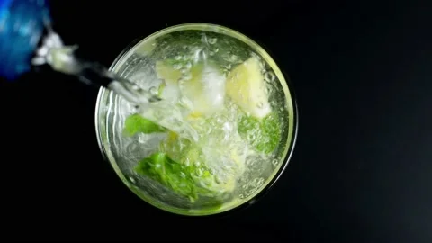 Close-up refreshing soda tonic. Pour carbonated water into a glass of lime and Video stock 148168532