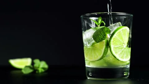 Close-up refreshing soda tonic. Pour carbonated water into a glass of lime and Stock-Footage 148168715