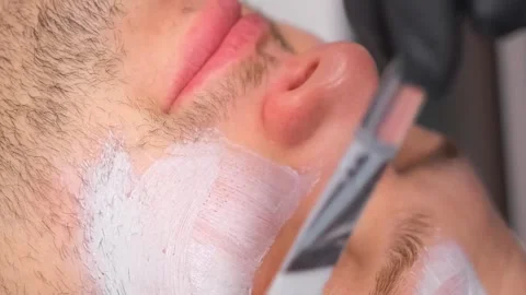 Close-up of a relaxed man's face while putting a mask on his face. A man at an Stock Footage 250356344