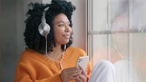Close up relaxed young Afro American woman listening browsing music at window 4K Stock Footage 229673944