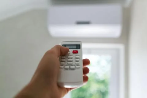 Close-up of remote control for conditioner in man hand. Stock Photos