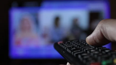 Close-up of a remote control held by a man while changing channels compulsively Stock Footage 120567757